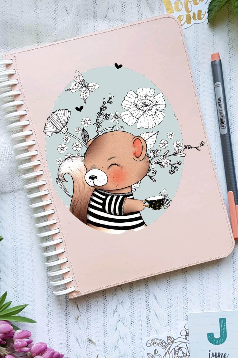 Pink notepad with colored squirrel pattern and black and white flowers.