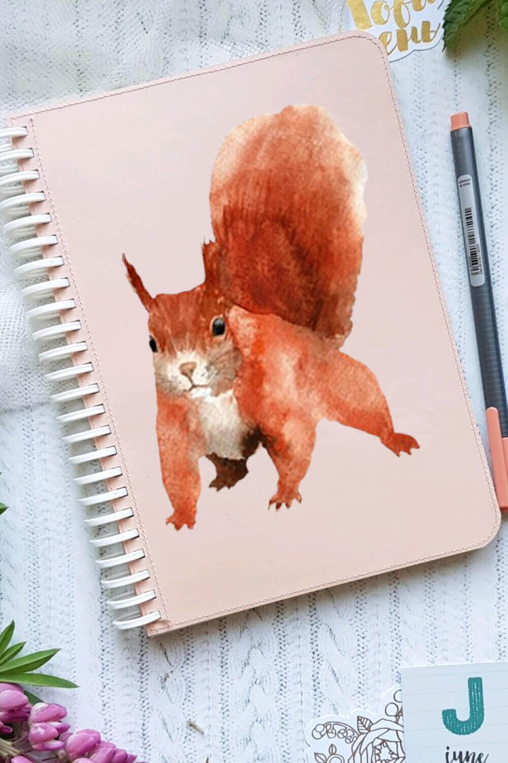 Red squirrel painted in watercolor on the cover of a notebook.