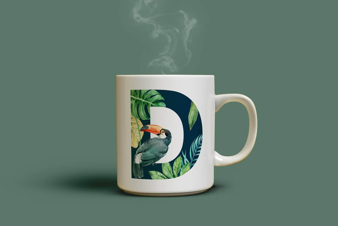The letter D is painted on a white cup decorated with tropical leaves and a cockatoo bird.