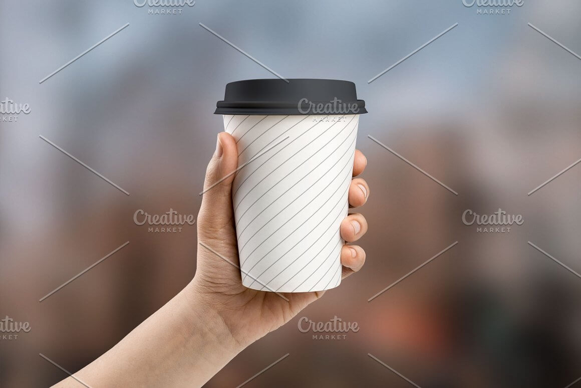 Simple patterns in gray stripes on a white coffee cup with a black lid.