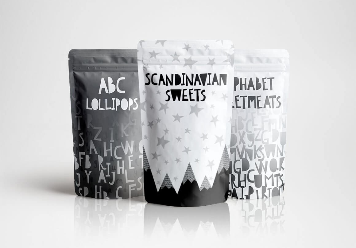 Three bags with a black and white drawing and inscriptions: ABC Lollipops, Scandinavian Sweets, Alphabet Eltments.
