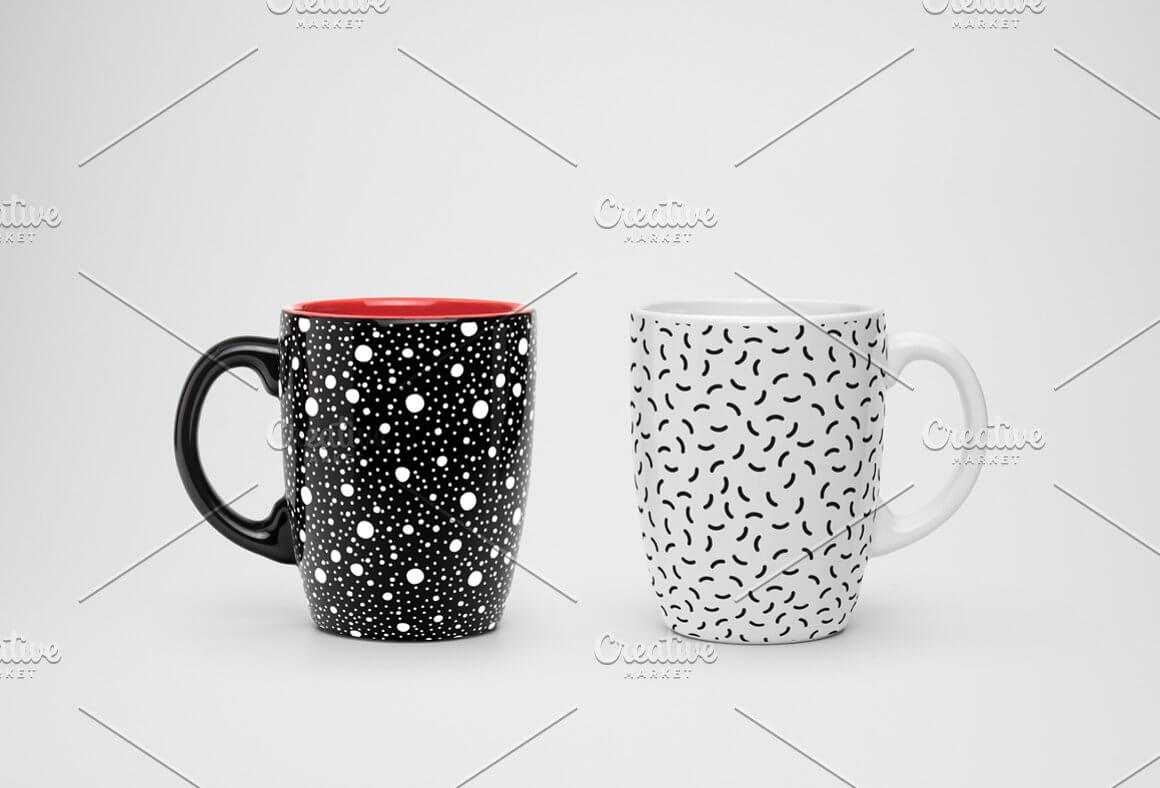 A white cup with a design of small sticks in a chaotic pattern and a black cup with white dots of different sizes.