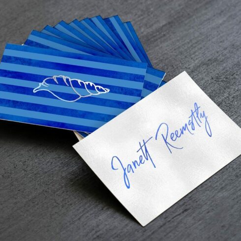 Blue cards with a croissant design, one white card with the name Janett Reemstly.