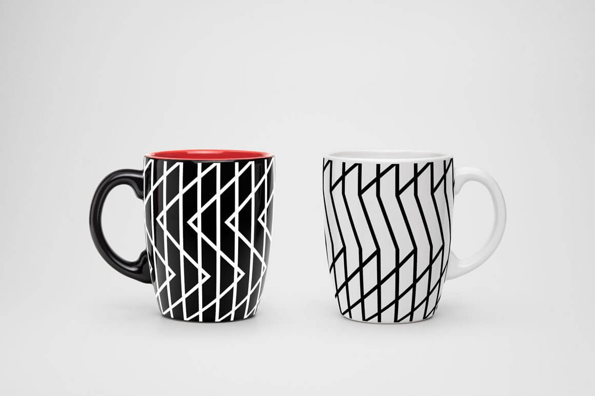Two cups in white and black with a geometric design on a white background.