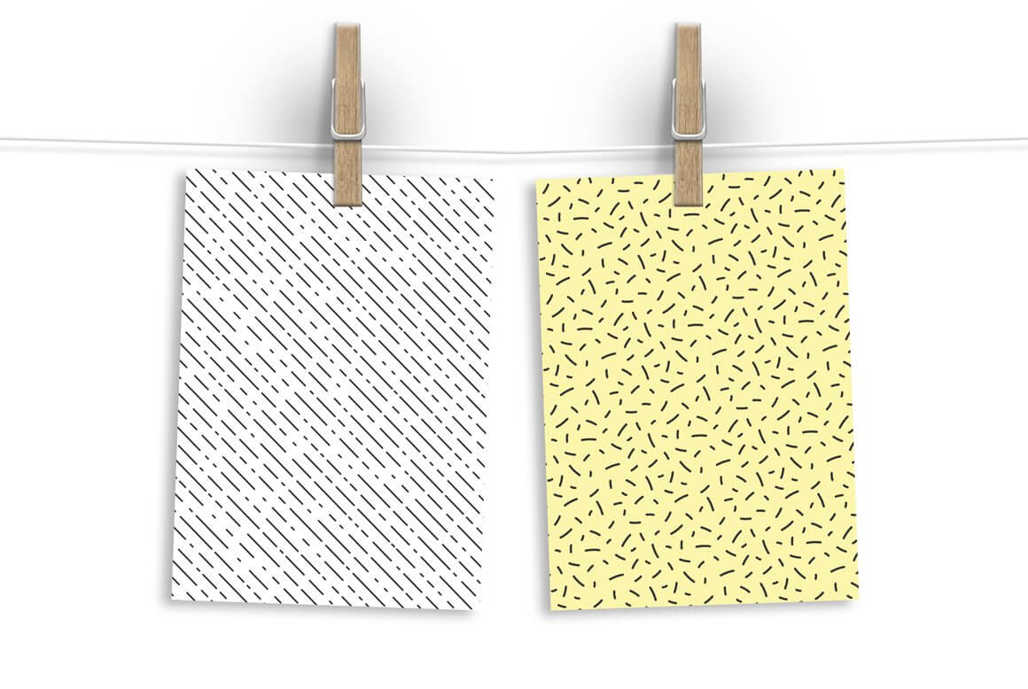 One white paper with a diagonal line design and yellow paper with a pattern of black sticks in a chaotic pattern.