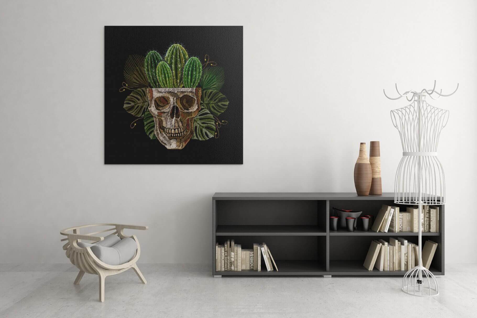 Embroidery of a skull from which cacti grow on a huge black picture.