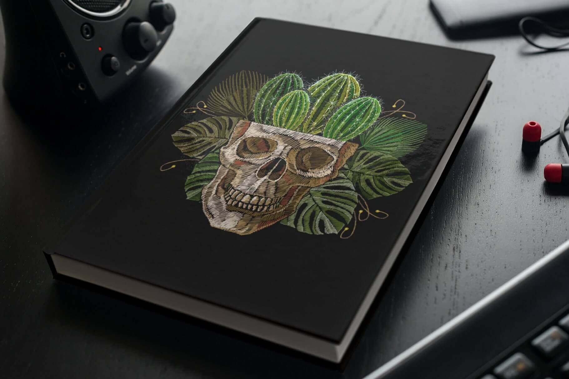 Embroidered skull, from which cacti grow, on the book's black palette.