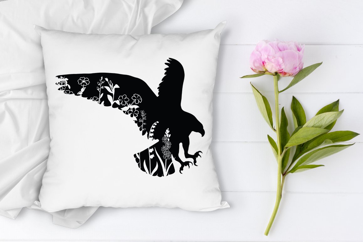 Print on a pillow with a flower next to it.