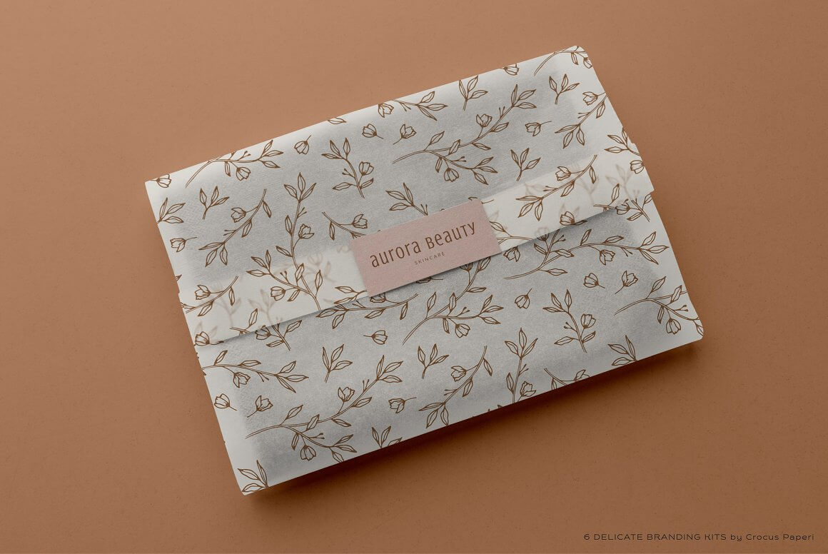 The item is wrapped in gift paper with a floral print, and the edge of the gift paper is sealed with a sticker that says aurora beauty skincare.
