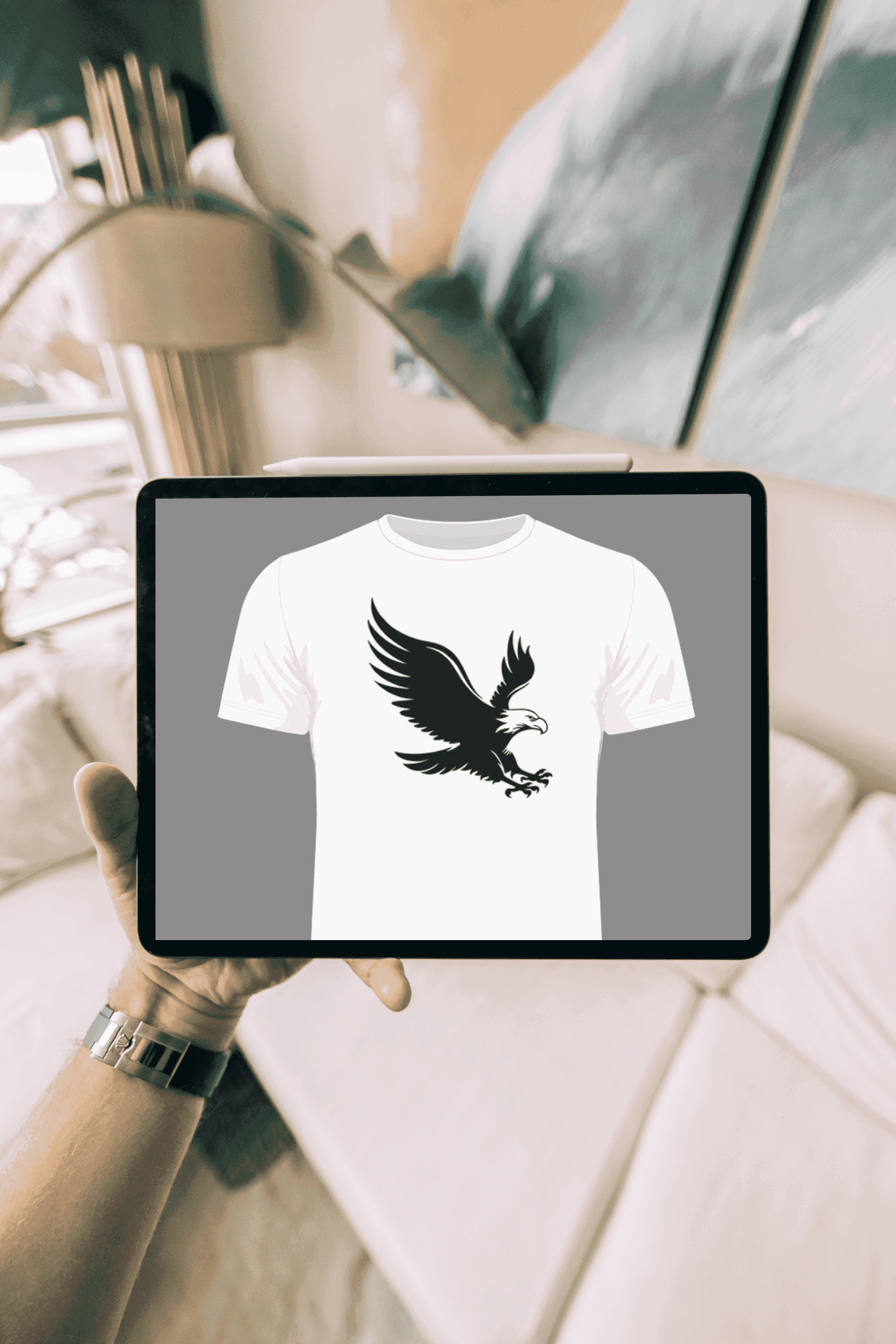 Person holding up a t - shirt with a bird on it.