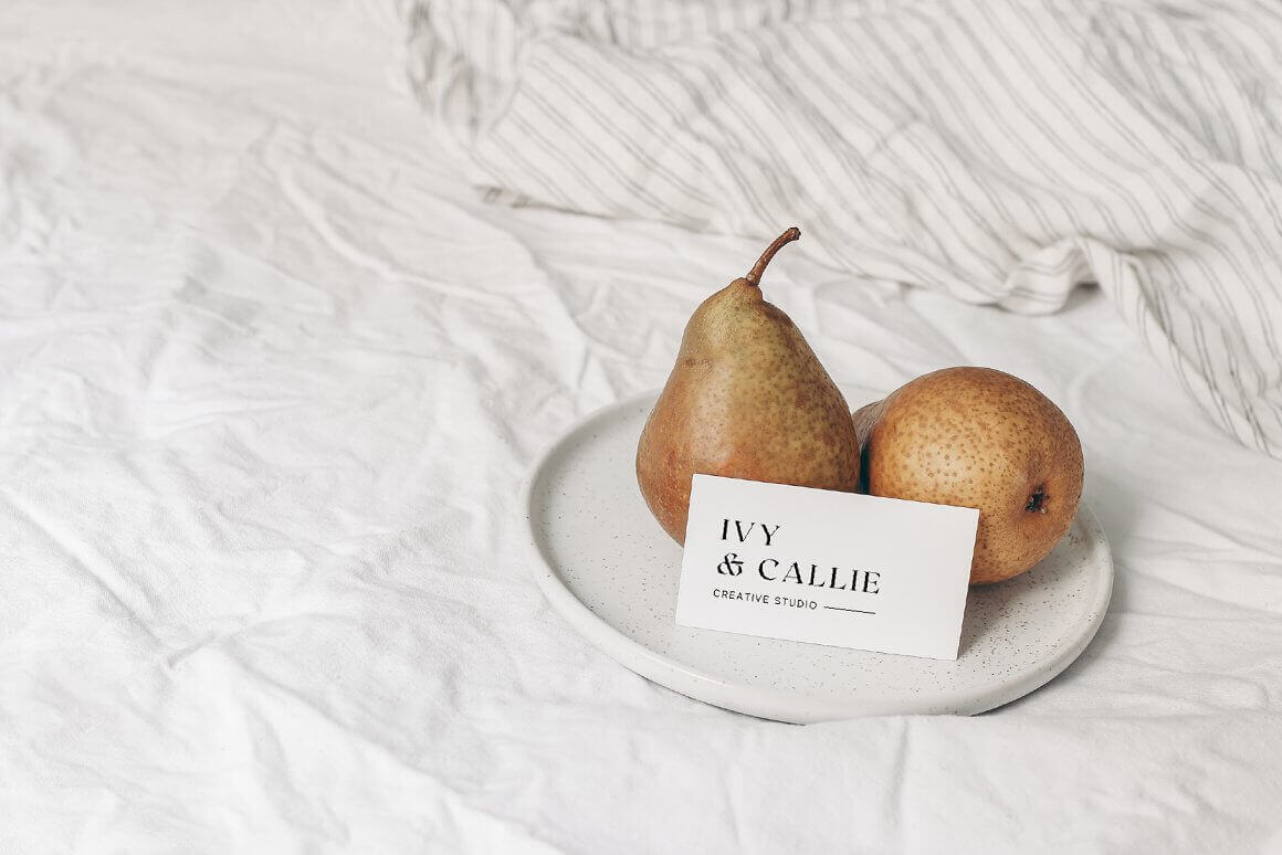 Two pears lie in a plate, and next to them is a card with the Ivy & Callie logo is drawn.