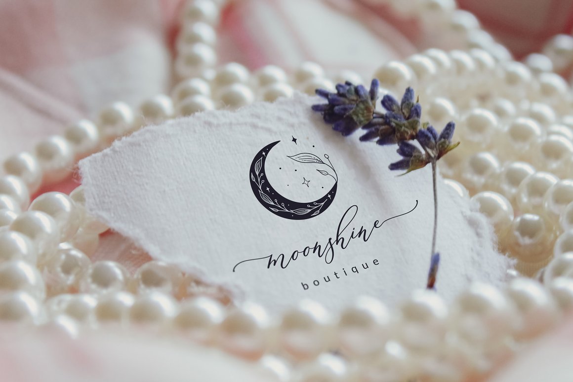 A card with a logo with a moon and an inscription lies in pearls with a branch of lavender.