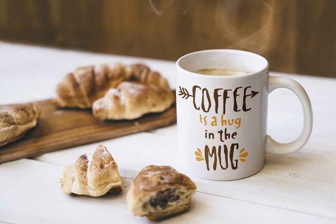 Dinner table with croissants and a white cup of coffee with inscriptions Spaghetti font.