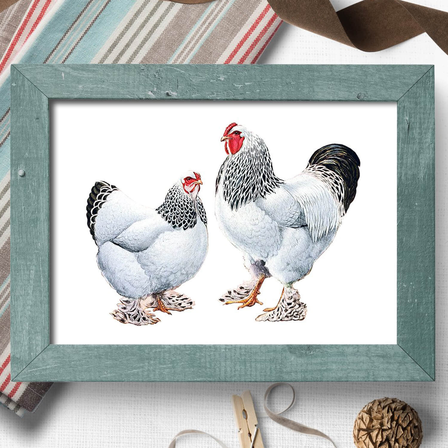 A chicken and a rooster on a picture with a white background and a wooden frame.