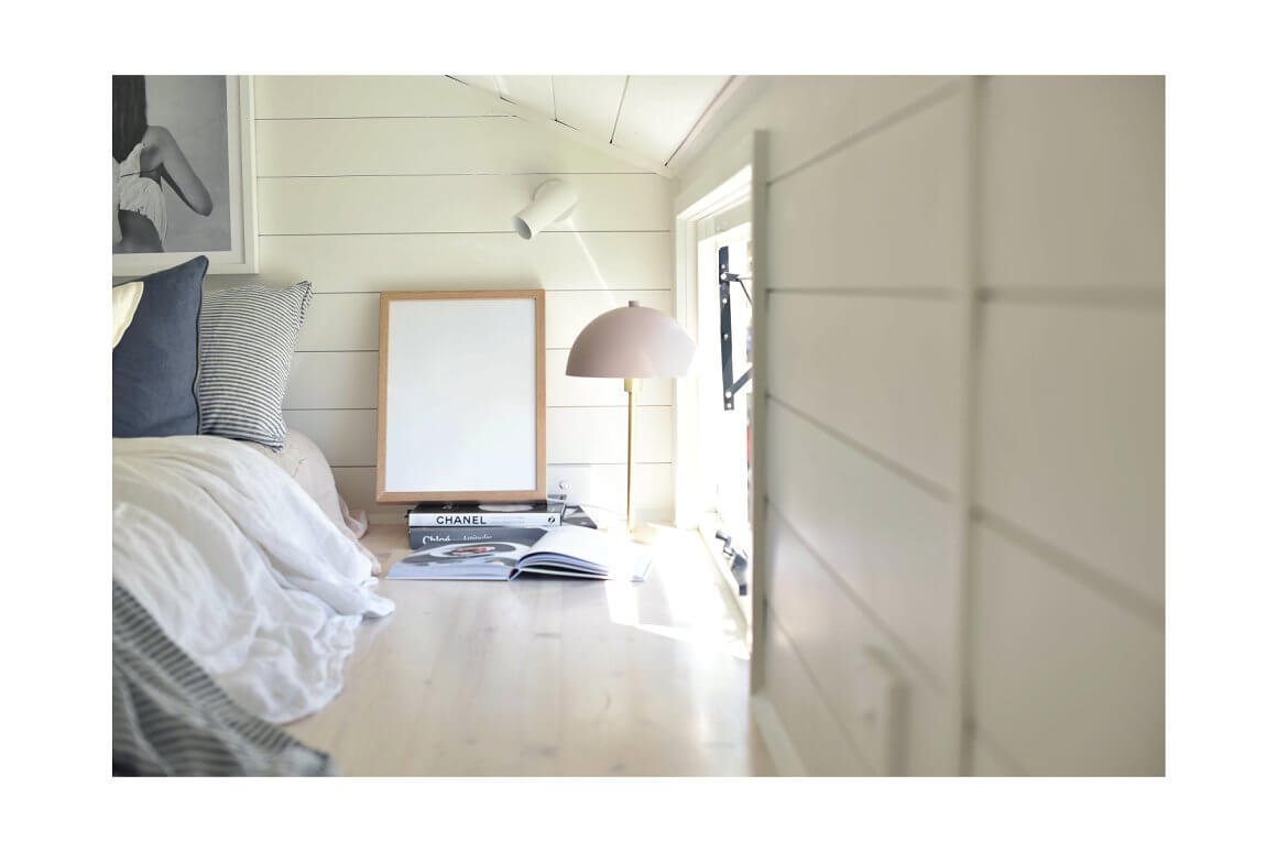Photo with the interior of the bedroom on the attic floor in white.