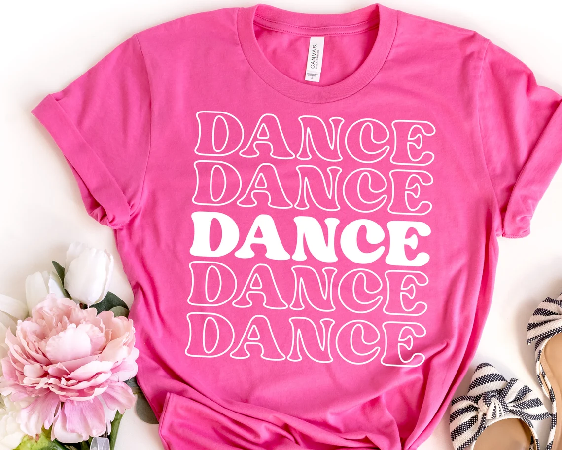 Dancing, dancing, dancing inscription on a pink T-shirt.