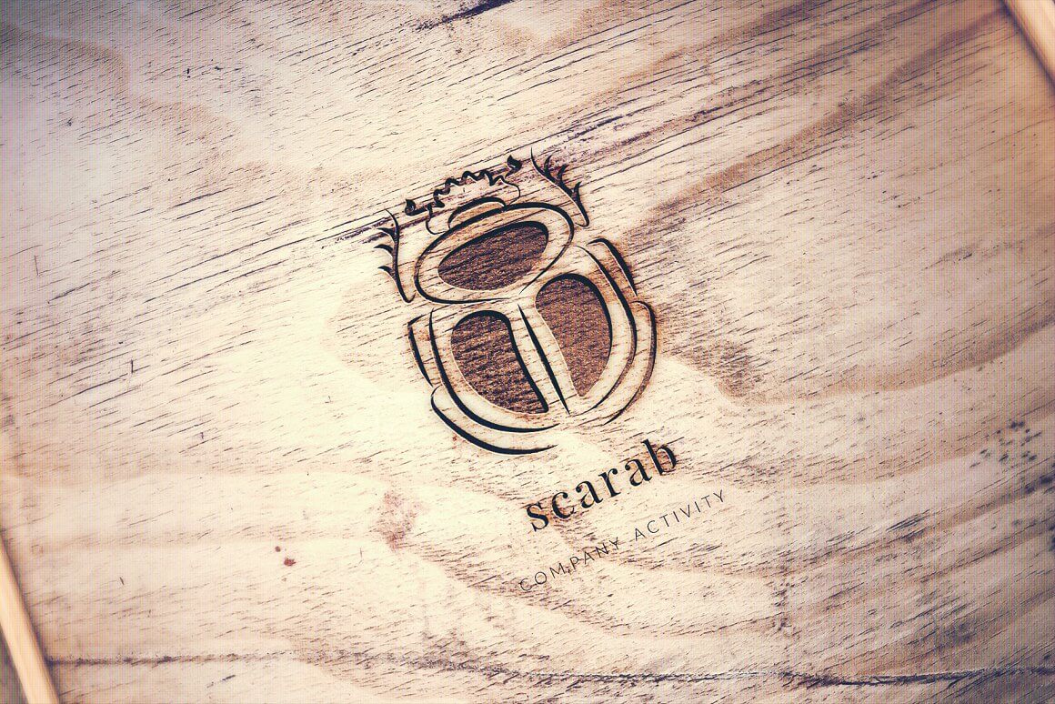 Scorched scarab logo on a wooden background.