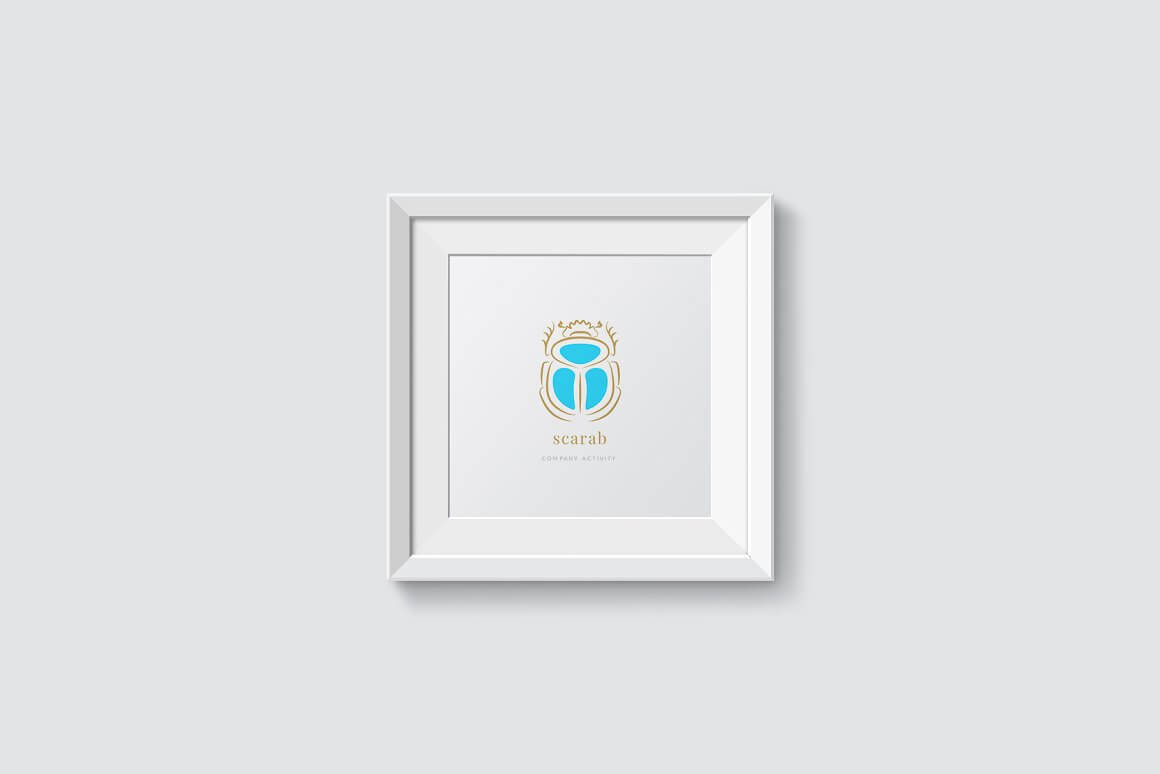 On a white wall hangs a white painting depicting a blue scarab.