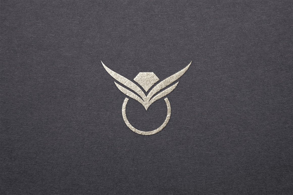 Large silver jewelry ring logo on a structural gray background.