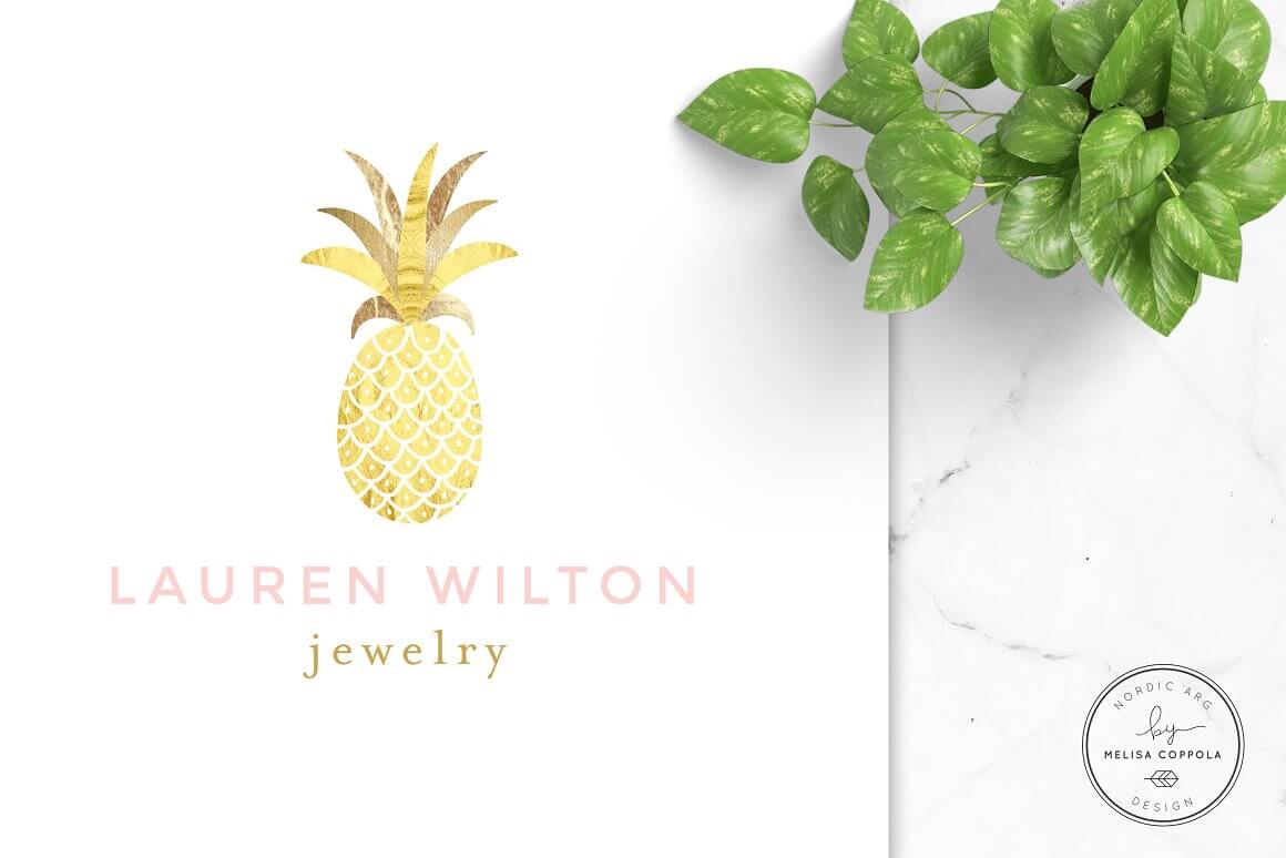 Golden pineapple logo design on a white sheet resting on a white marble with "Lauren Wilton, Jewelry" written on it.