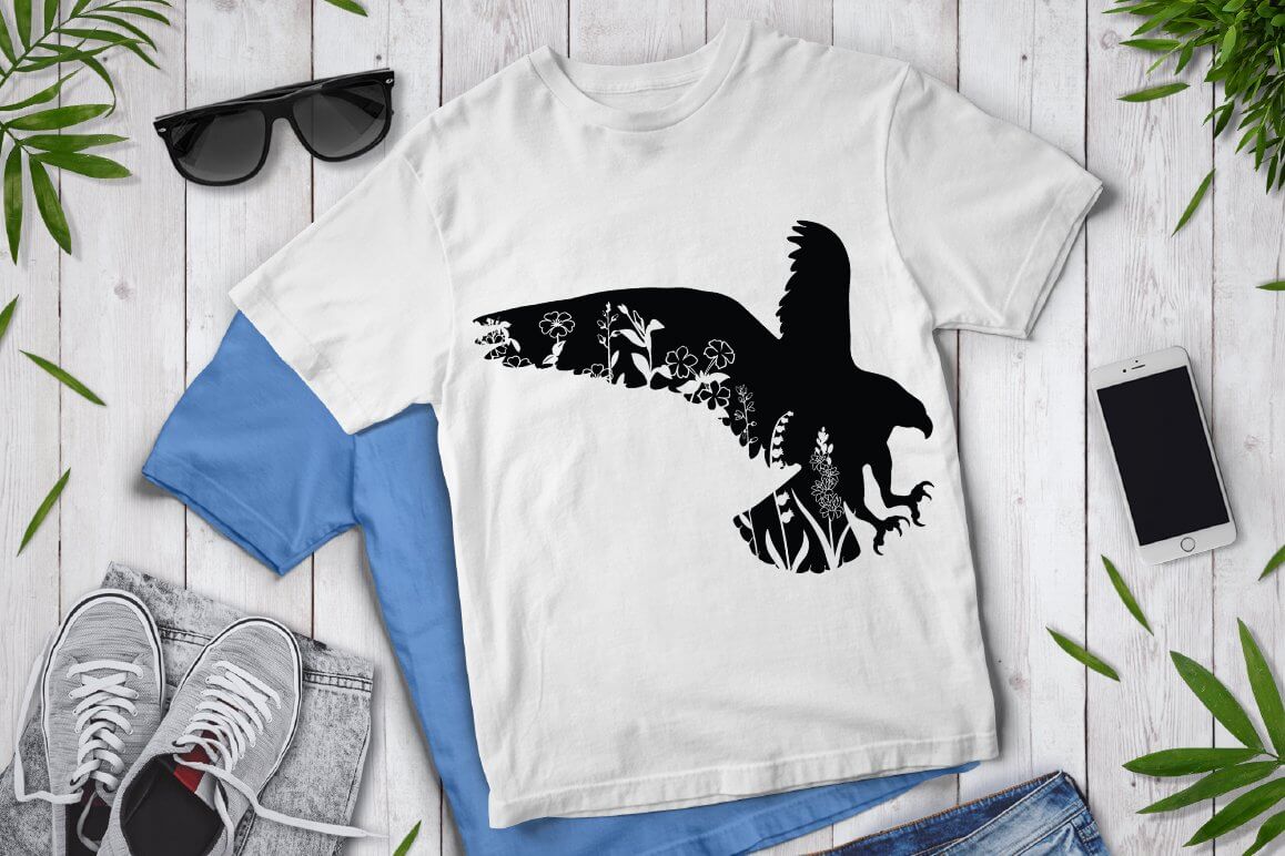 There is a floral eagle on a white and blue T-shirt.