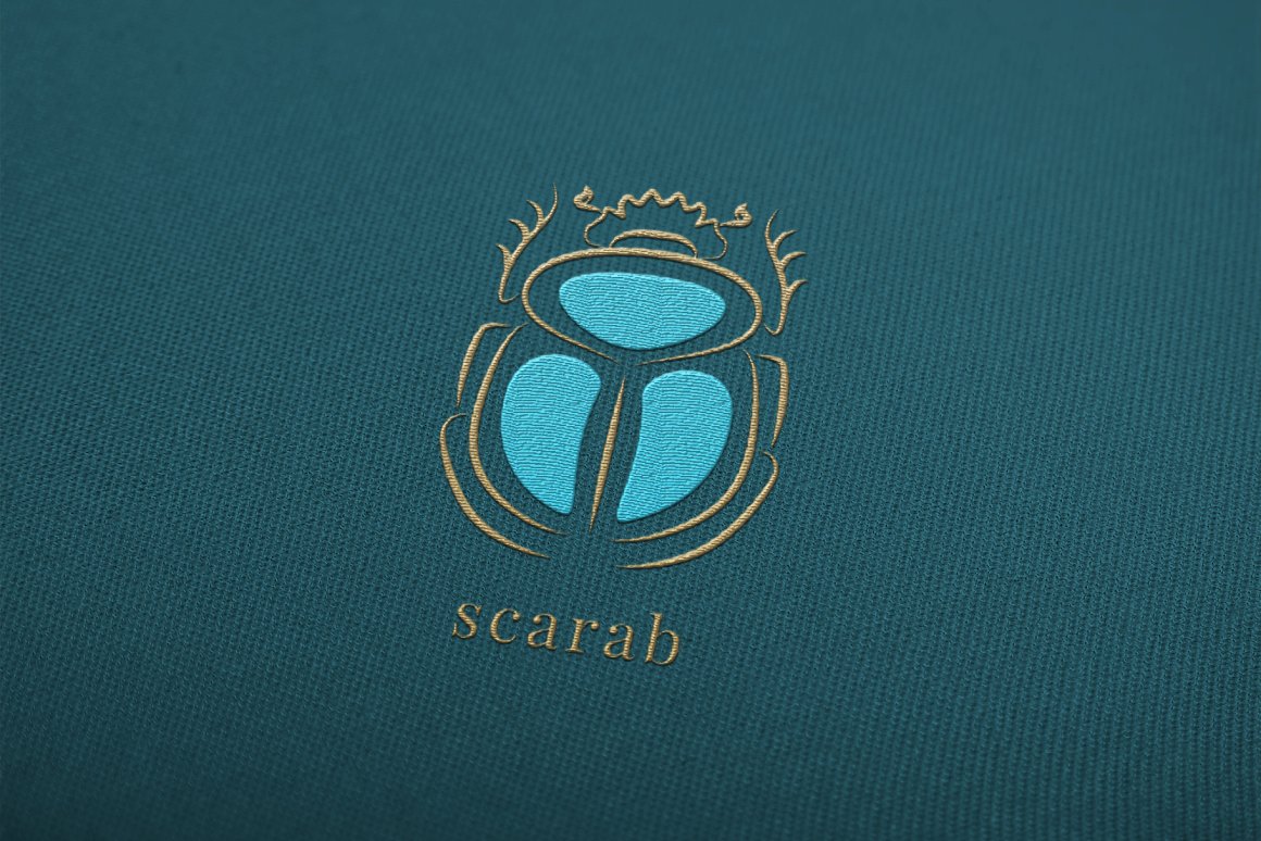 Blue scarab logo embroidered on blue fabric.