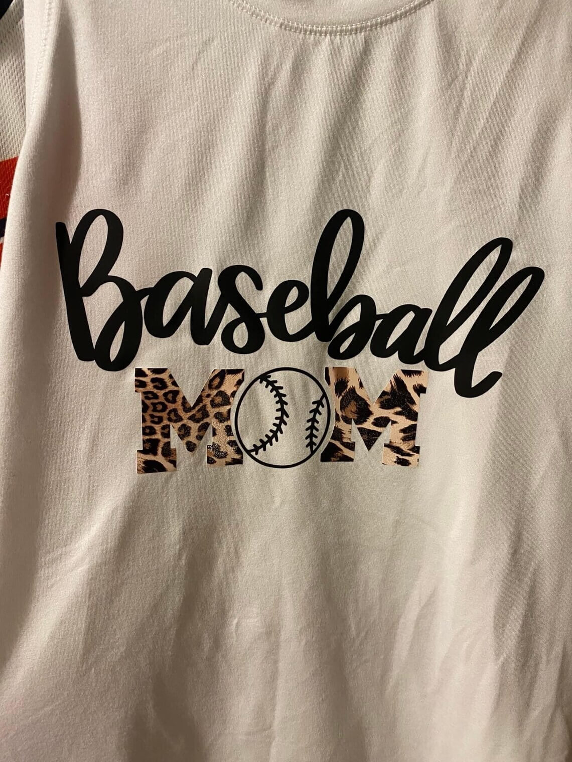 Inscription Baseball Mom on the beige t-shirt.