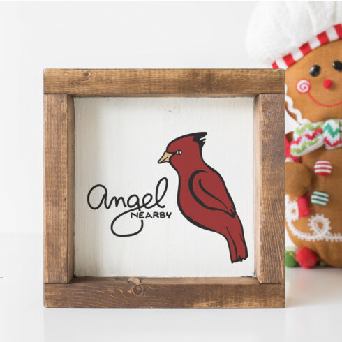 Wooden frame with a picture of a red bird and a gingerbread man.