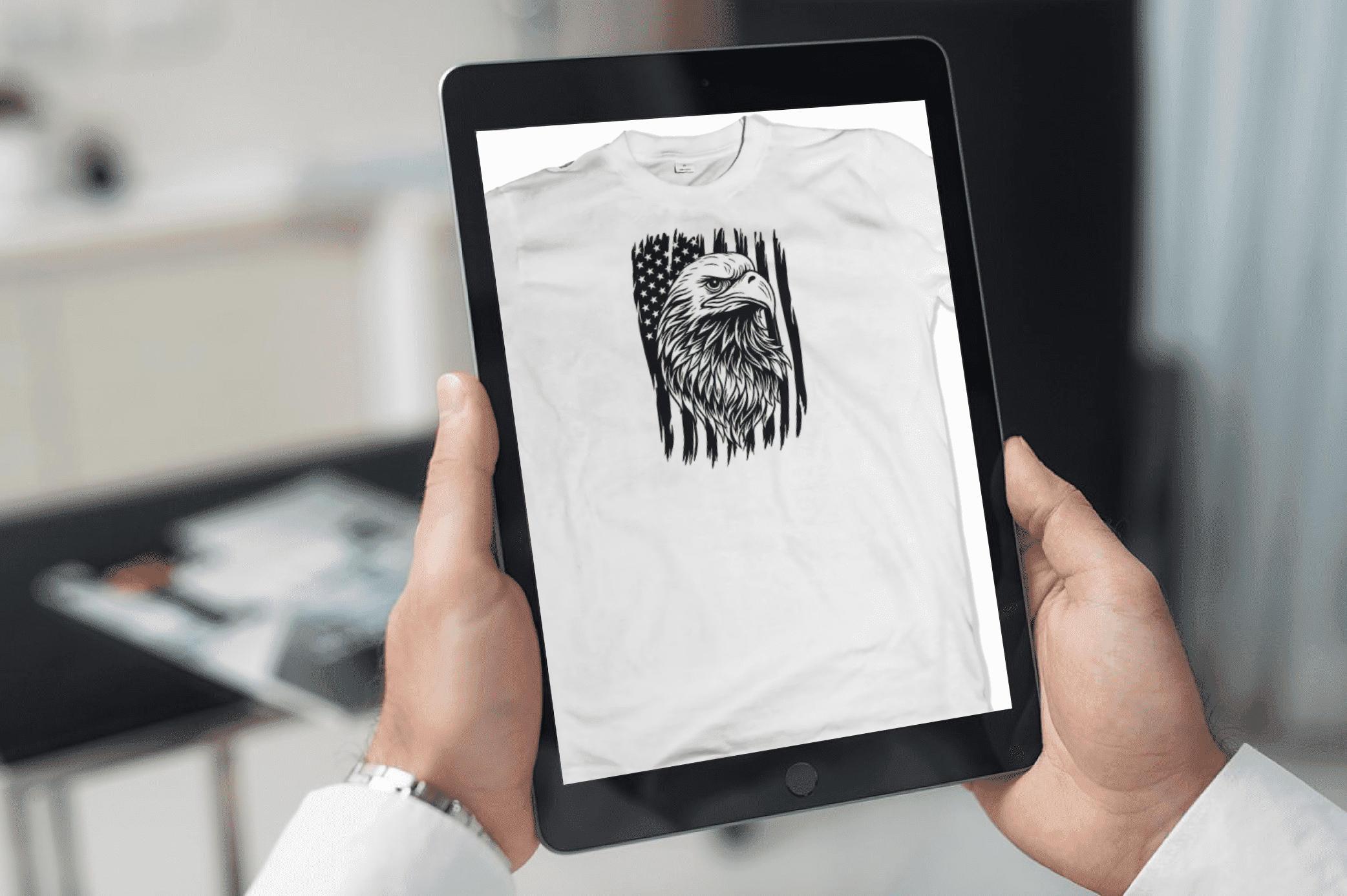 Person holding a tablet with a t - shirt on it.