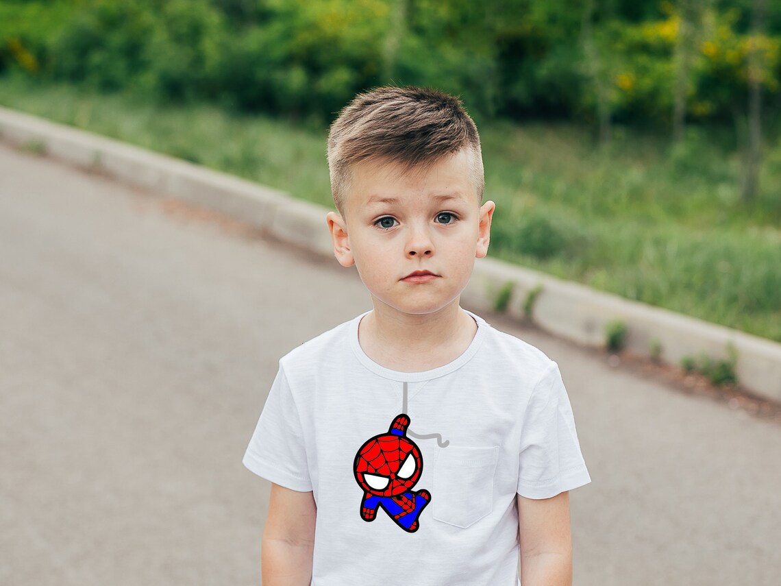 A teenager with spiderman on a white t-shirt.