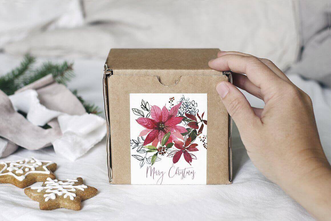 The cardboard box is decorated with a white postcard with the image of a poinsettia.