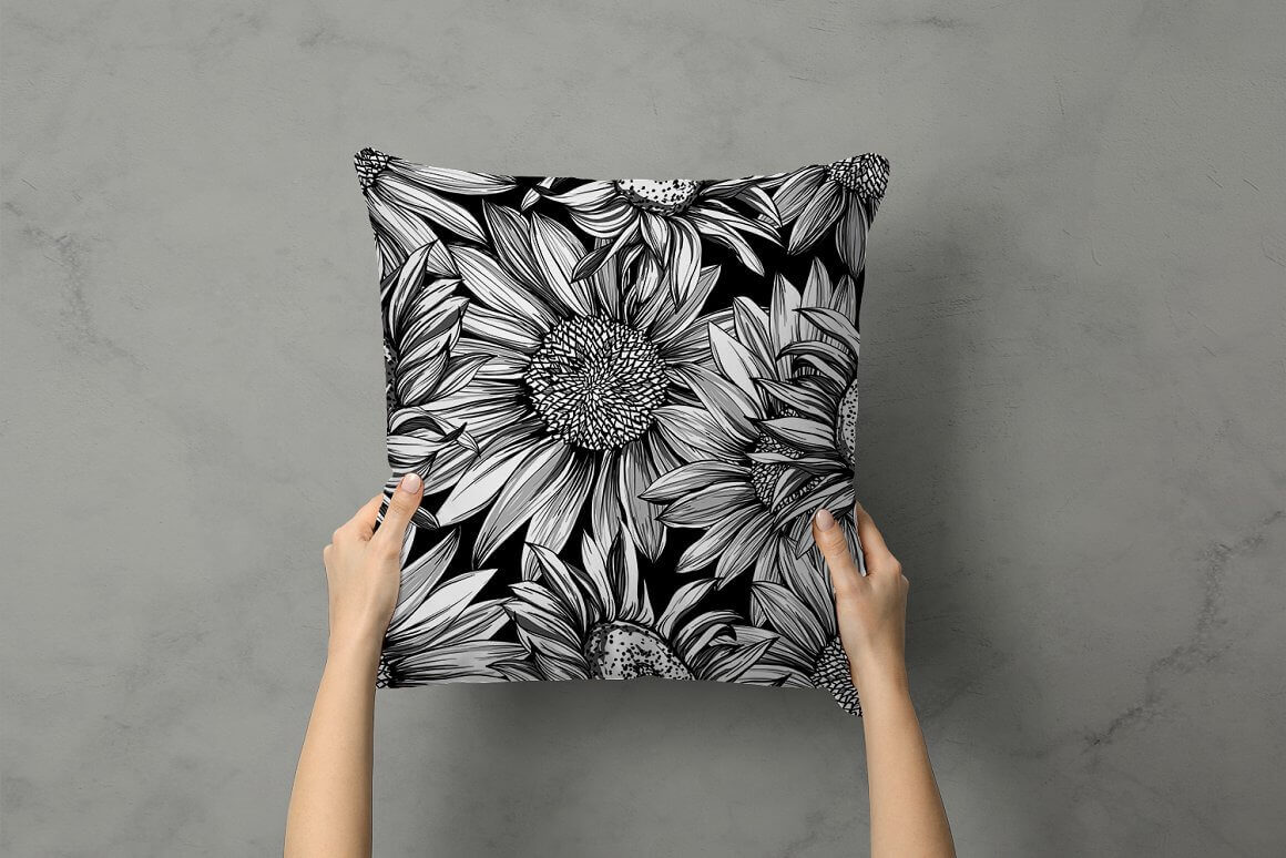 Image of a black pillow with white sunflowers.