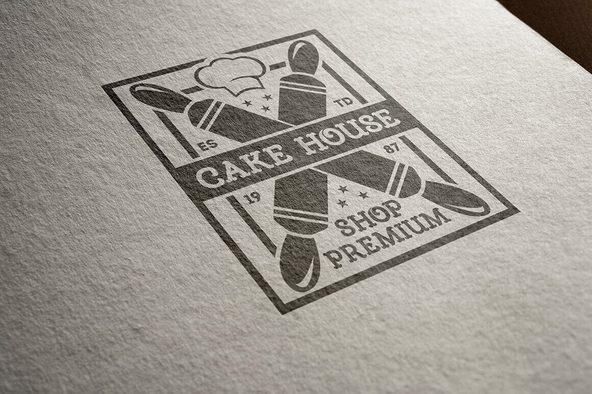 Large black "Cake House" logo close-up on matte paper.