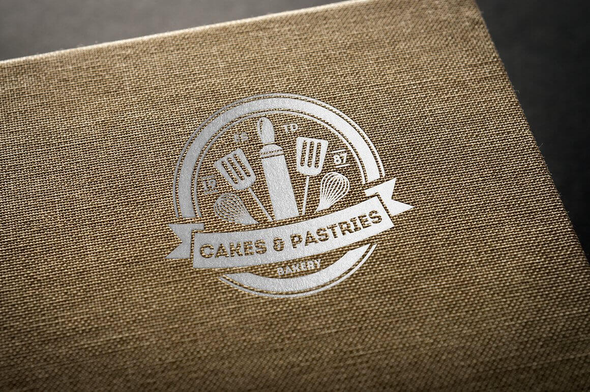 Large silver "Cakes & Pastries, Bakery" logo on brown burlap.