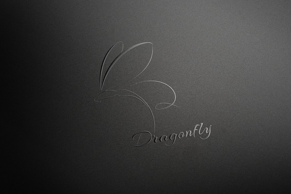 Black dragonfly logo on a dark background at a slight angle.
