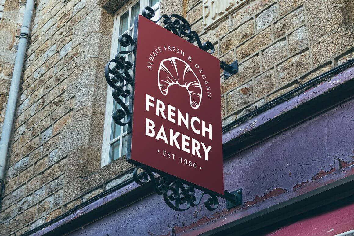 Red signboard of a French bakery with forged elements.