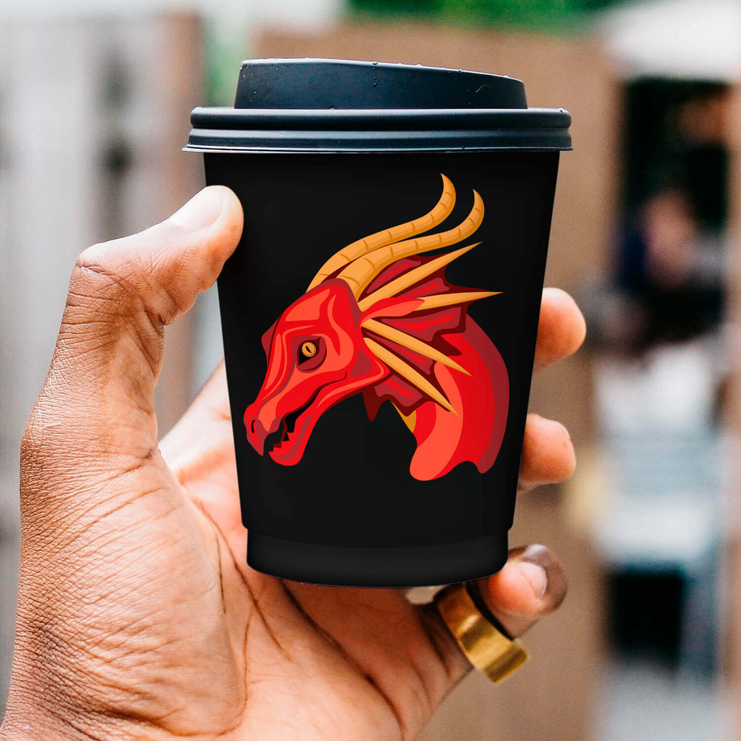 Hand holding a black cup with a red horse on it.