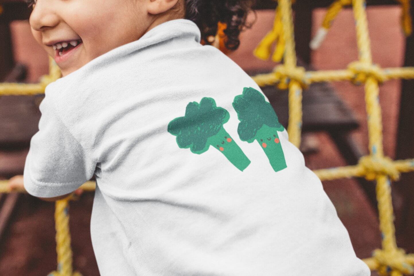 Two green broccoli are drawn on the boy's white T-shirt.