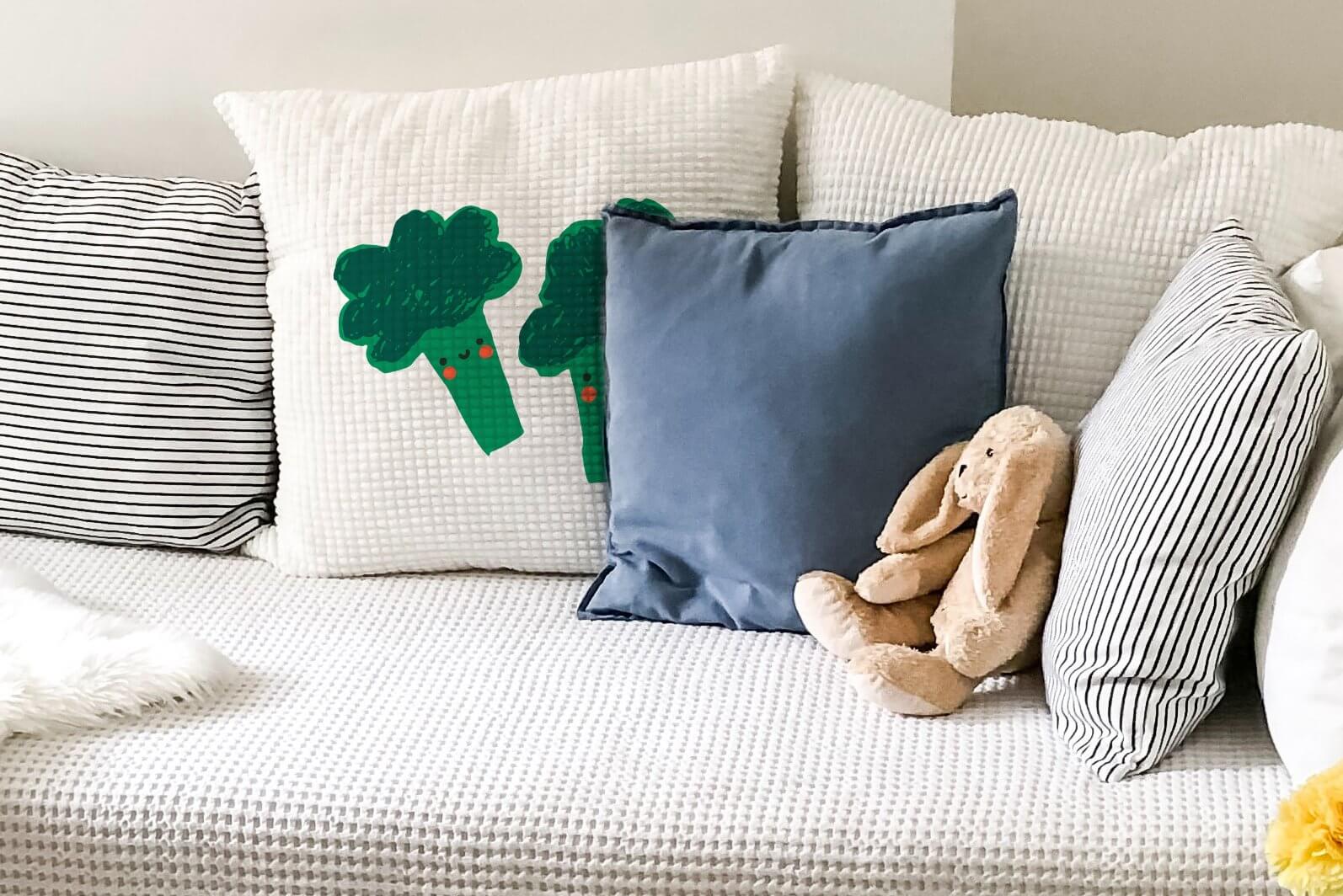 Two green cheerful broccoli are painted on the waffle texture of the pillow.