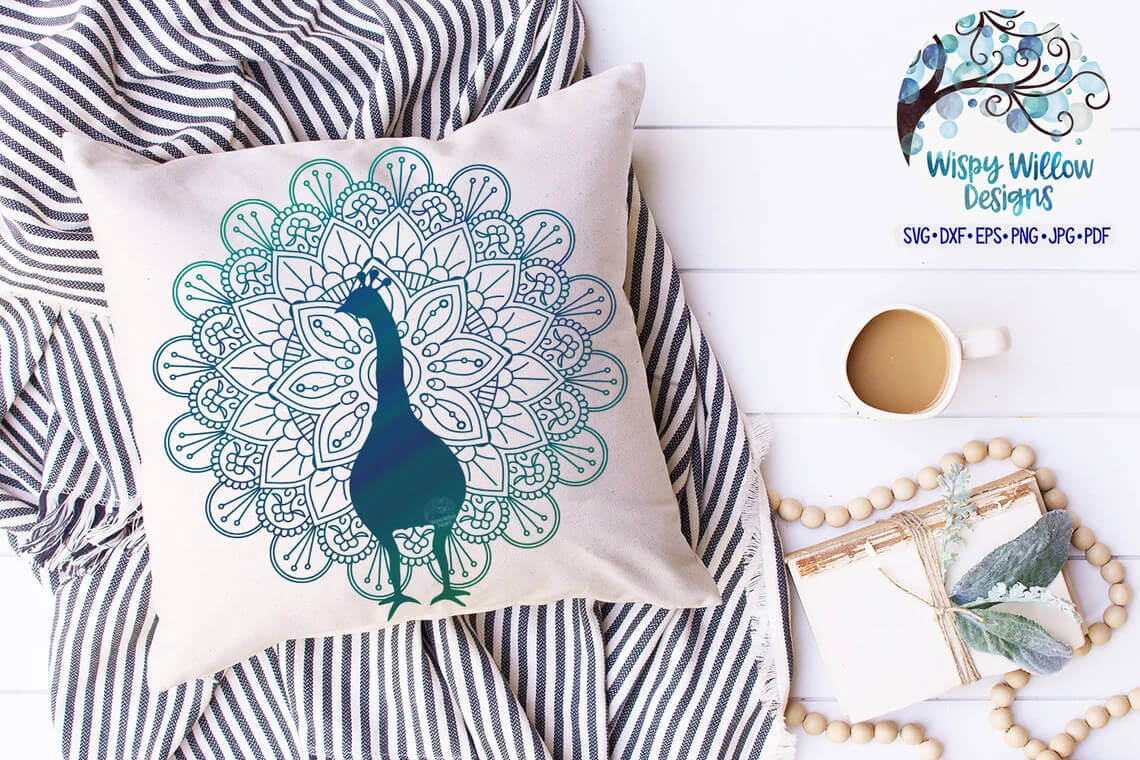 A white pillow with a peacock image lies on a striped fabric.