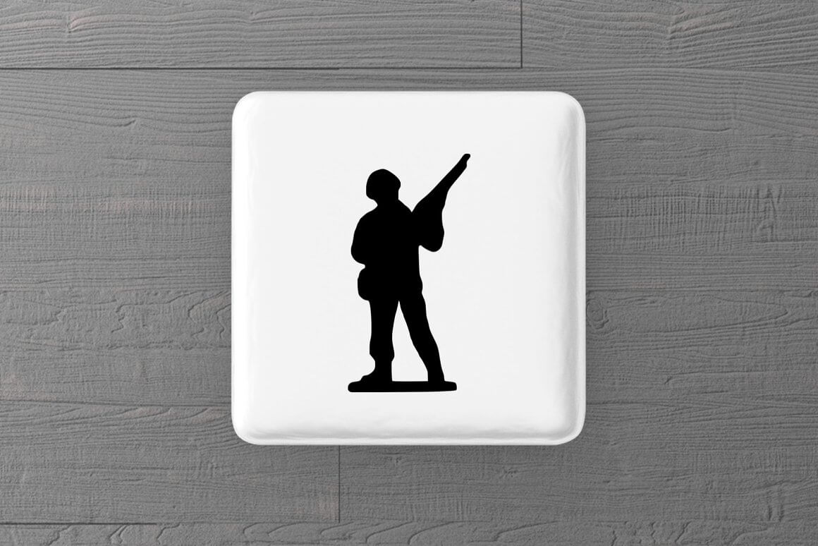 A white button with the image of a soldier in a helmet is depicted on a gray wooden background.