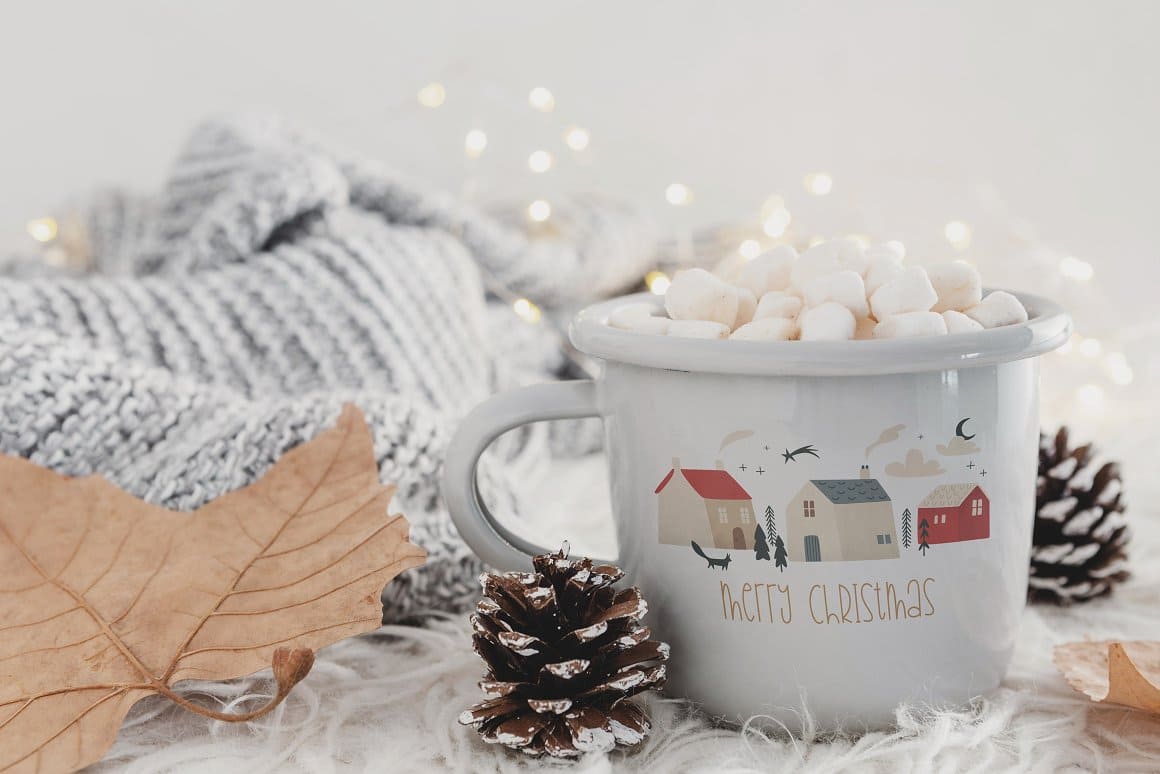 Image of a cup with a Christmas design and a warm drink with small marshmallows inside.