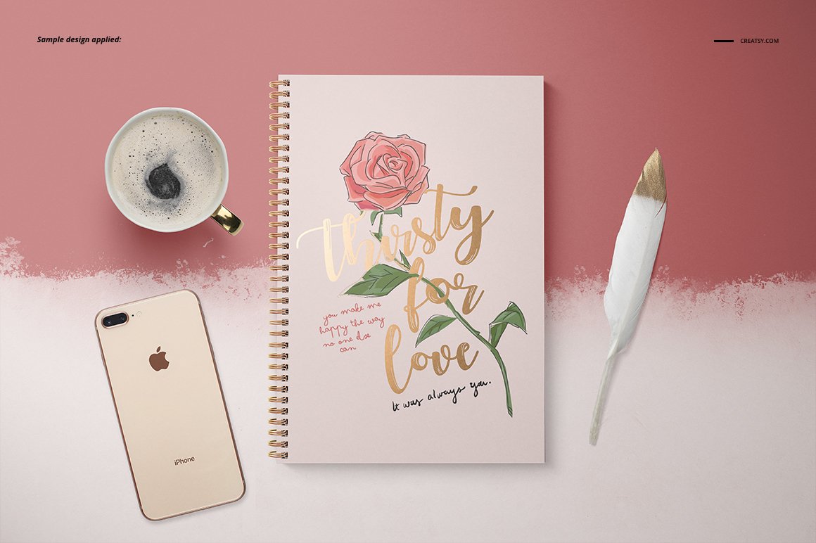 Rose print on notebook with phone and pen.