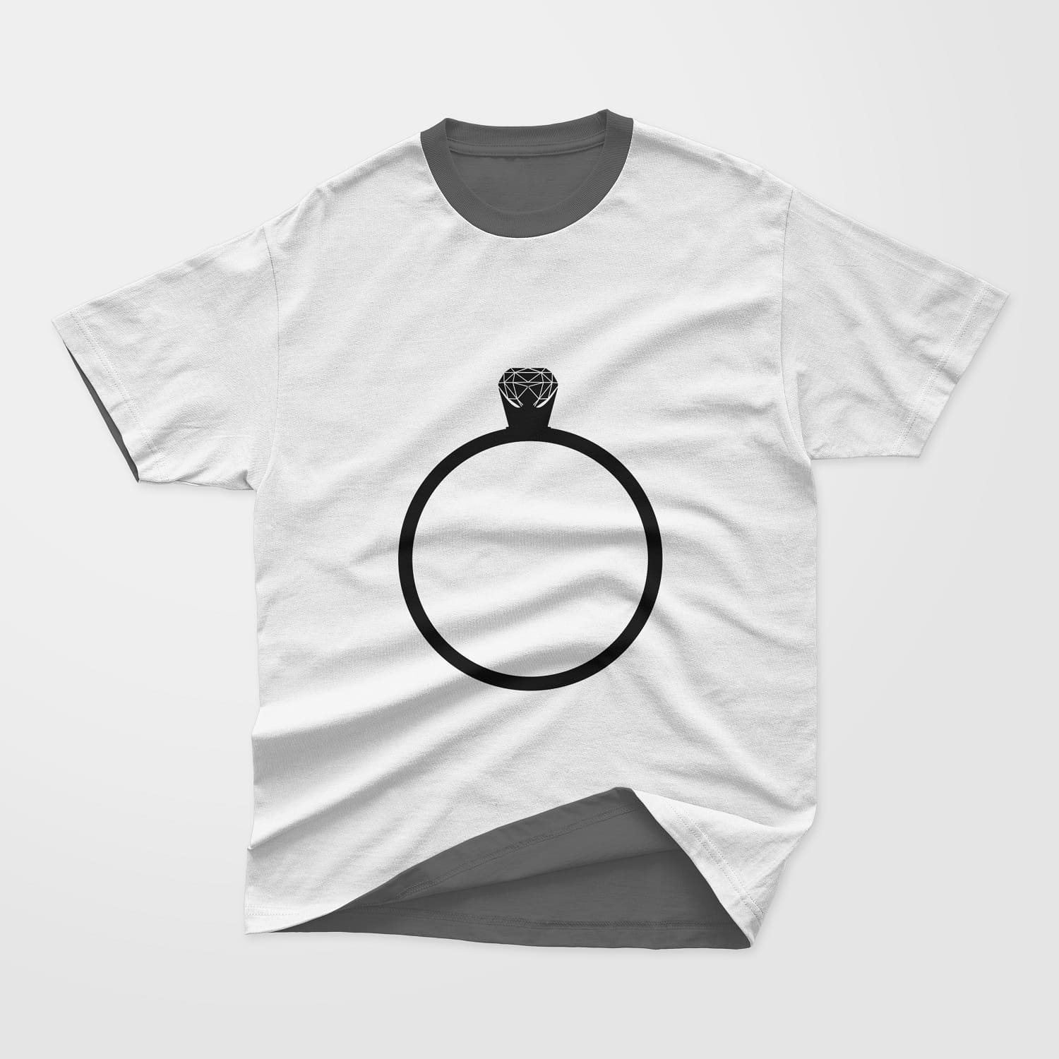 Silhouette image of a wedding ring with a small jewel on a light t-shirt.