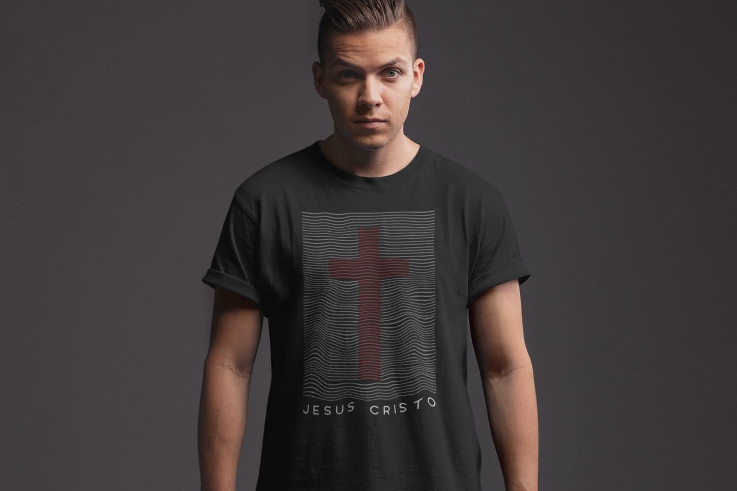 The inscription Jesus Christ under a red cross on a black t-shirt of a white guy.