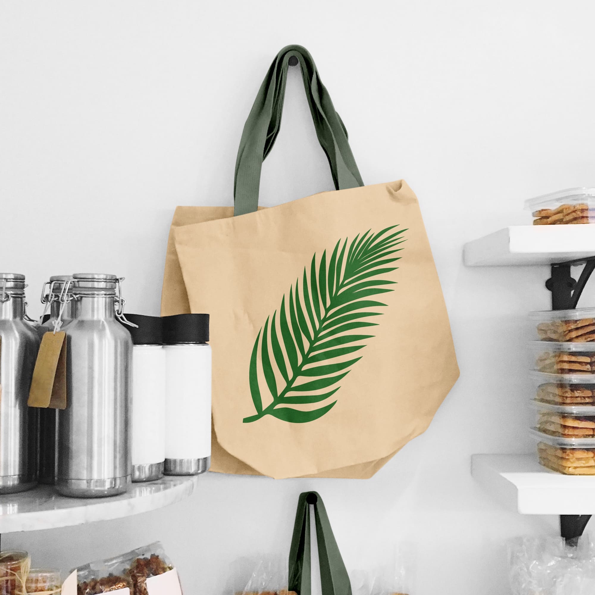 A long palm leaf is drawn on the beige bag.