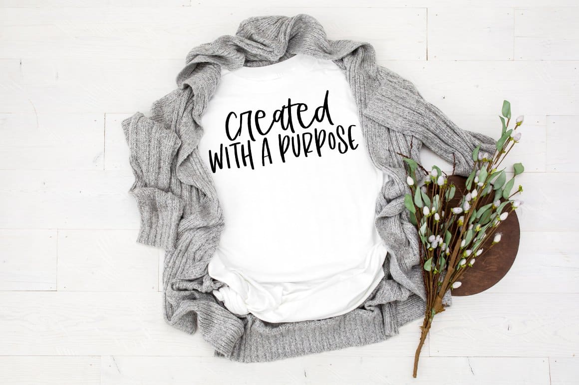 "Created with a purpose" written in black on a white cotton t-shirt.