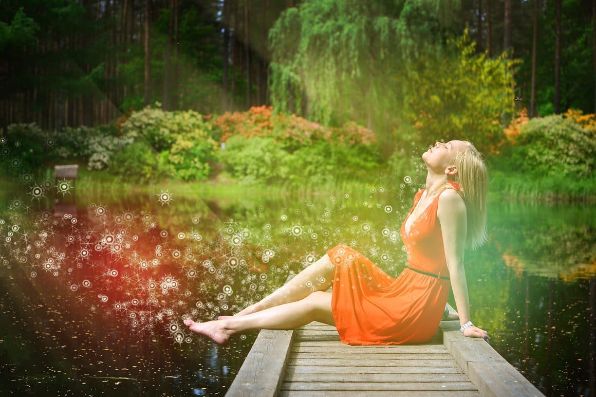 Brushes of stars and sparkles on the photo with a blonde sitting on a bridge on a lake.