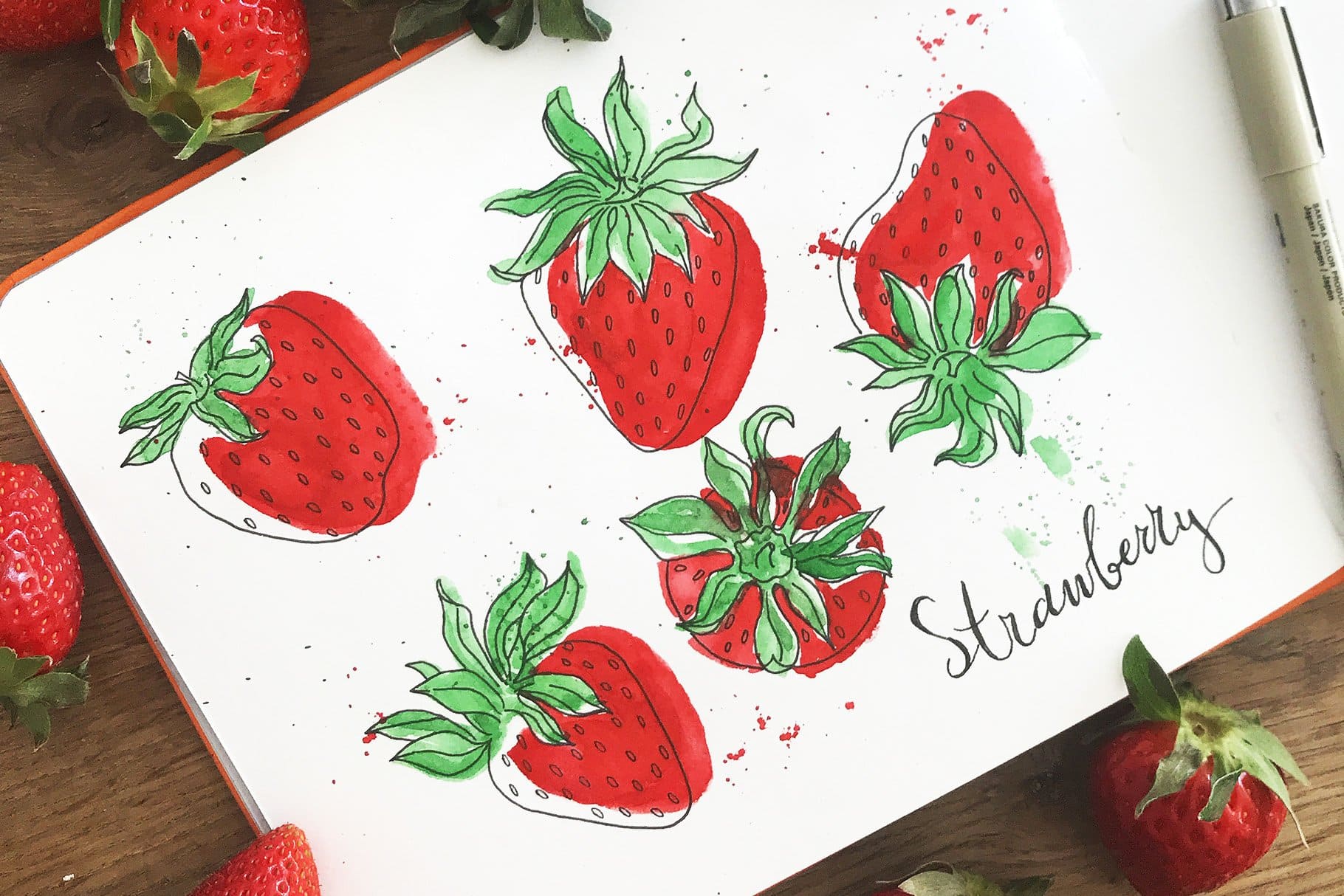 Watercolor red strawberry on album sheet.