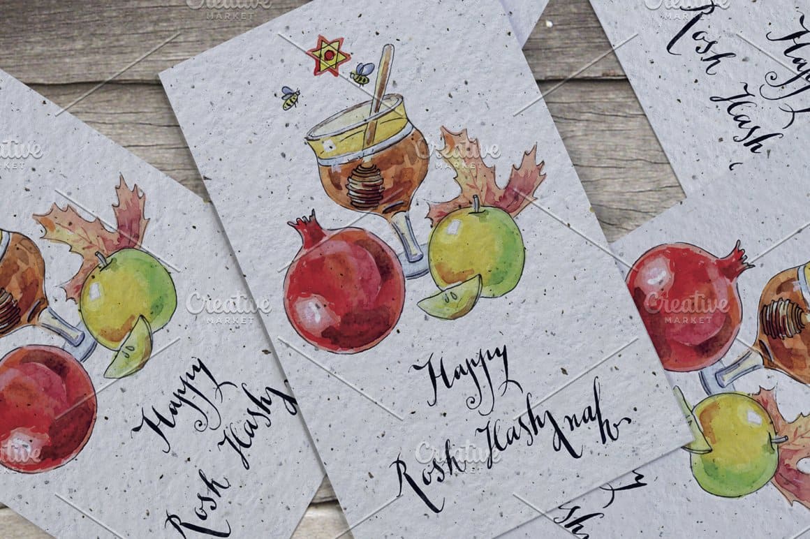 White cards with the image of a pomegranate and other fruits, as well as a festive drink with honey for the holiday of Purim.